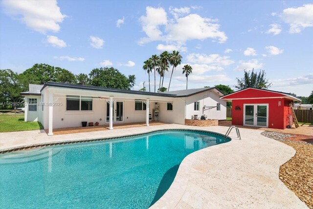 1550 NW 114th Ave, Plantation, FL 33323 - back of house with french doors, a patio, an outdoor pool, an outbuilding, and a storage structure
