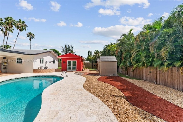 1550 NW 114th Ave, Plantation, FL 33323 - view of swimming pool with french doors, a fenced backyard, a patio area, and a shed