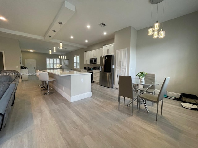 1087 Chenille Cir, Weston, FL 33327 - kitchen featuring appliances with stainless steel finishes, open floor plan, light wood-style floors, recessed lighting, and white cabinetry