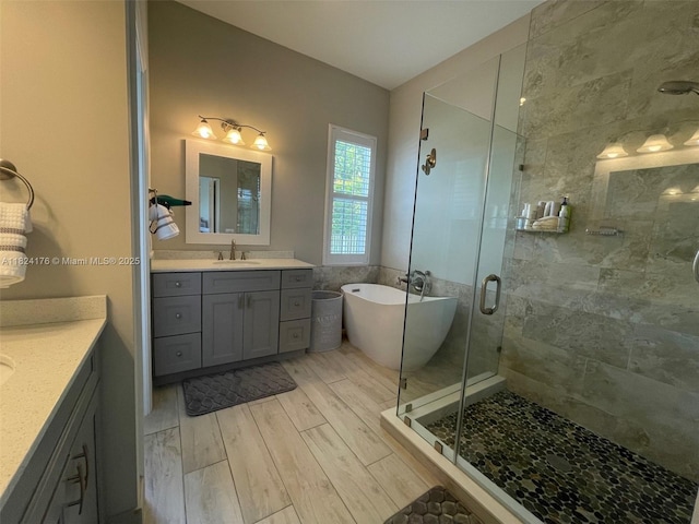1087 Chenille Cir, Weston, FL 33327 - bathroom featuring two vanities, a stall shower, wood finished floors, and a freestanding bath