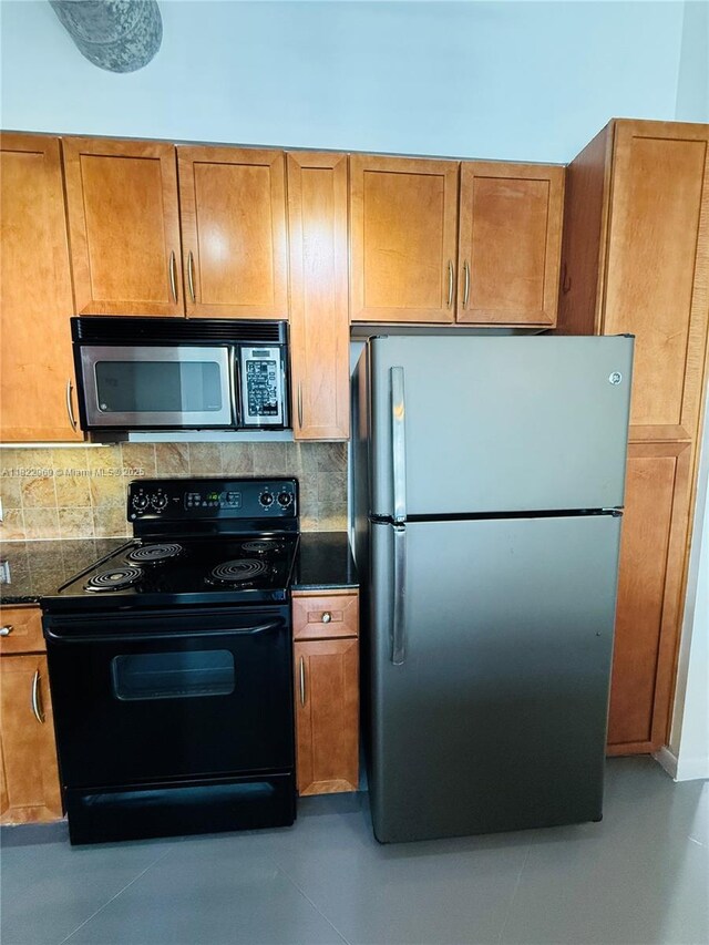 2001 Biscayne Blvd Unit 2402, Miami, FL 33137 - kitchen featuring stainless steel appliances, dark countertops, decorative backsplash, and brown cabinets