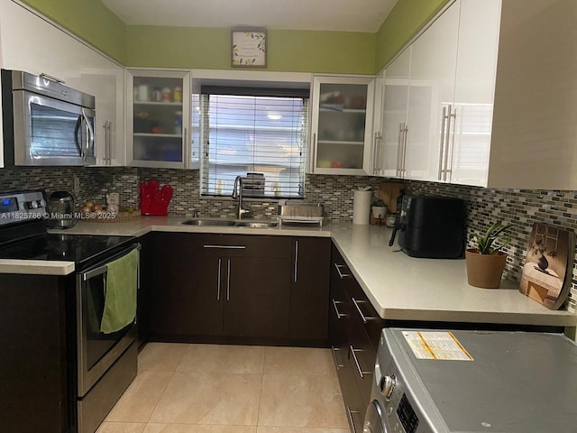 19001 NE 14th Ave Unit 325, Miami, FL 33179 - kitchen with stainless steel appliances, light countertops, light tile patterned floors, and tasteful backsplash