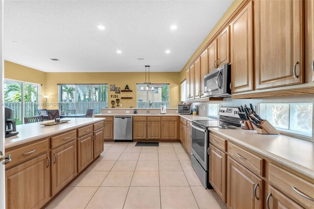 452 NE 20th Ter, Homestead, FL 33033 - kitchen with stainless steel appliances, light countertops, recessed lighting, a peninsula, and light tile patterned flooring