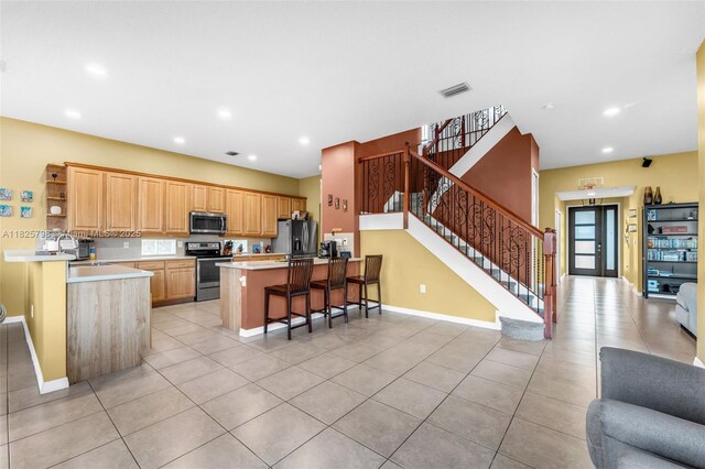 452 NE 20th Ter, Homestead, FL 33033 - kitchen featuring appliances with stainless steel finishes, a kitchen bar, open shelves, a peninsula, and open floor plan