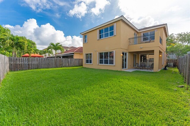 452 NE 20th Ter, Homestead, FL 33033 - back of property with stucco siding, a balcony, a fenced backyard, and a patio area