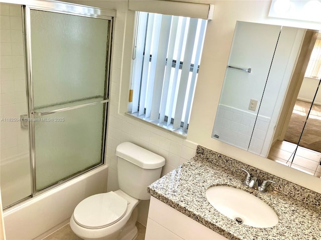 9041 Sunrise Lakes Blvd Unit 208, Sunrise, FL 33322 - bathroom with vanity, tile walls, and combined bath / shower with glass door
