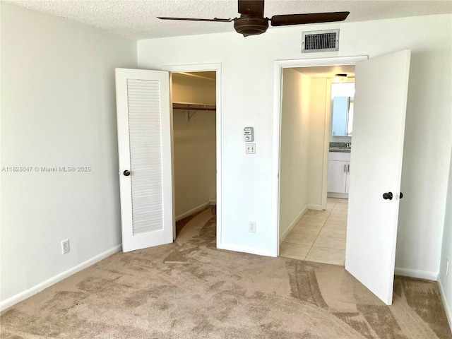 9041 Sunrise Lakes Blvd Unit 208, Sunrise, FL 33322 - unfurnished bedroom with a spacious closet, light carpet, a textured ceiling, a closet, and ceiling fan