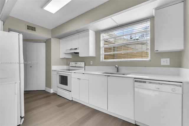 2246 SE 27th Dr Unit 204-D, Homestead, FL 33035 - kitchen featuring white appliances, under cabinet range hood, light wood-style flooring, and white cabinetry
