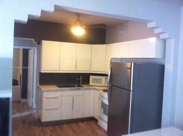 1325 Meridian Ave Unit 6, Miami Beach, FL 33139 - kitchen with white appliances, dark wood-type flooring, white cabinetry, and light countertops