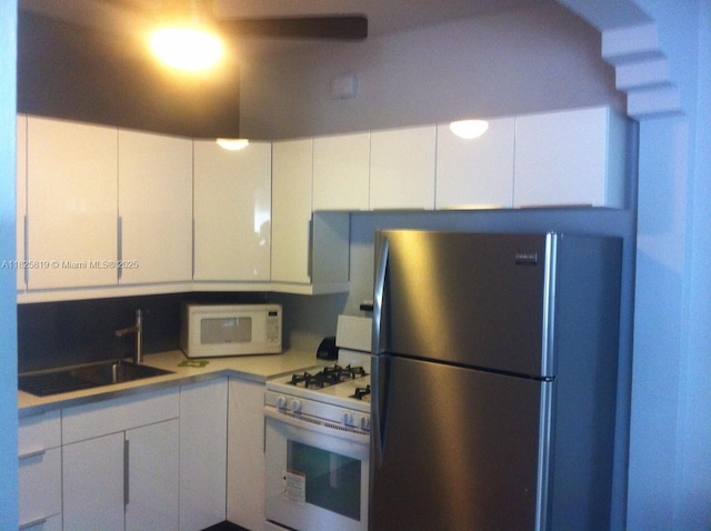 1325 Meridian Ave Unit 6, Miami Beach, FL 33139 - kitchen with white appliances, white cabinetry, and light countertops