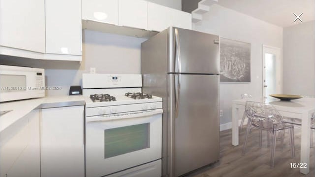 1325 Meridian Ave Unit 6, Miami Beach, FL 33139 - kitchen with white appliances, white cabinets, dark wood finished floors, and light countertops