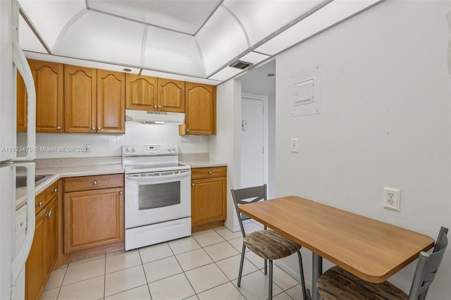 900 Saint Charles Pl Unit 420, Pembroke Pines, FL 33026 - kitchen with white electric range oven, under cabinet range hood, light tile patterned floors, light countertops, and tasteful backsplash