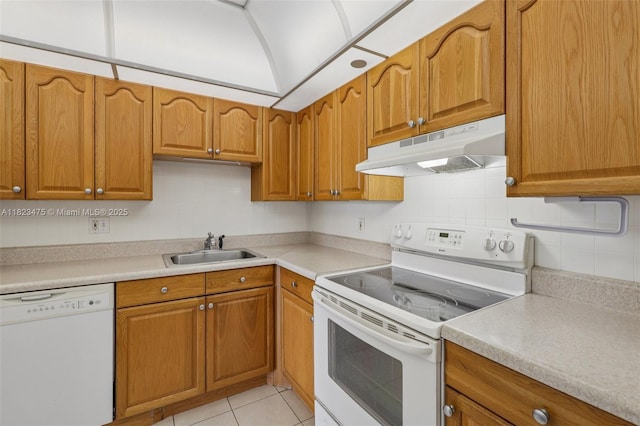 900 Saint Charles Pl Unit 420, Pembroke Pines, FL 33026 - kitchen featuring white appliances, under cabinet range hood, brown cabinetry, light countertops, and vaulted ceiling