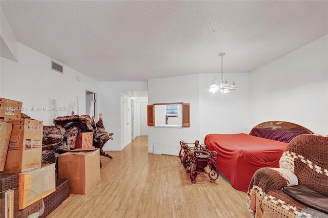 1750 NE 191st St Unit 106-1, Miami, FL 33179 - bedroom featuring light wood finished floors, a chandelier, and a textured ceiling