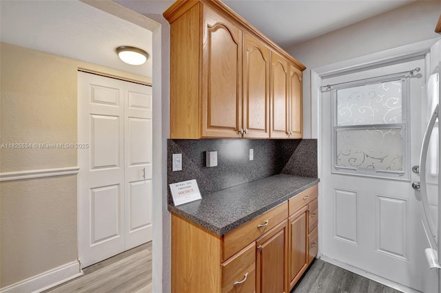 2097 S Ocean Unit 207, Hallandale Beach, FL 33009 - kitchen with wood finished floors, dark countertops, and backsplash