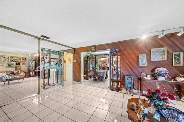 3820 SW 122nd Ave, Miami, FL 33175 - living room with rail lighting, wood walls, light tile patterned floors, and a textured ceiling