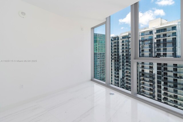 300 Biscayne Blvd Way Unit 3902, Miami, FL 33131 - empty room with floor to ceiling windows, a city view, and tile patterned flooring