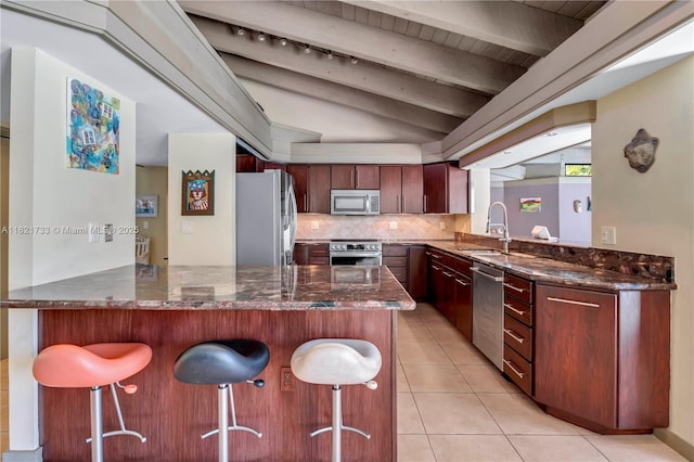 2691 SW 110th Way, Davie, FL 33328 - kitchen with appliances with stainless steel finishes, a breakfast bar, light tile patterned floors, tasteful backsplash, and dark stone countertops