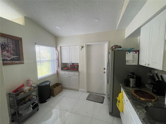 1716 SW Cordova St, Port St Lucie, FL 34987 - kitchen with a textured ceiling, white cabinets, and lofted ceiling