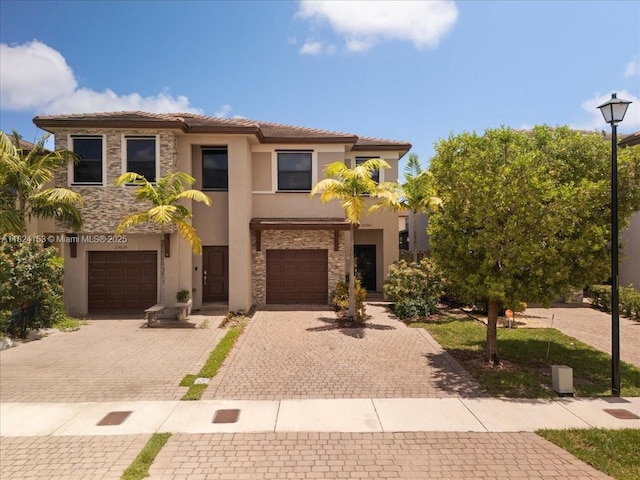 25041 SW 108th Ave, Homestead, FL 33032 - mediterranean / spanish-style house with stucco siding, decorative driveway, a garage, and stone siding