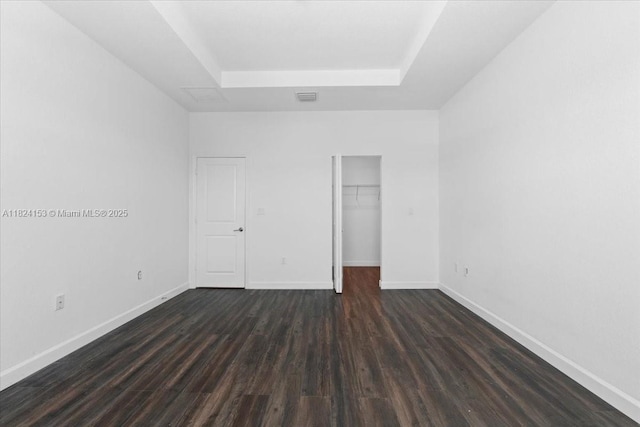 25041 SW 108th Ave, Homestead, FL 33032 - unfurnished bedroom with a tray ceiling, dark wood-type flooring, a walk in closet, and a closet