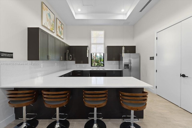25041 SW 108th Ave, Homestead, FL 33032 - kitchen with stainless steel fridge, light countertops, a peninsula, decorative backsplash, and a breakfast bar