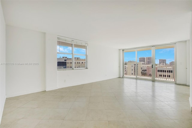 9500 W Bay Harbor Dr Unit 7H, Bay Harbor Islands, FL 33154 - tiled empty room featuring baseboards and floor to ceiling windows