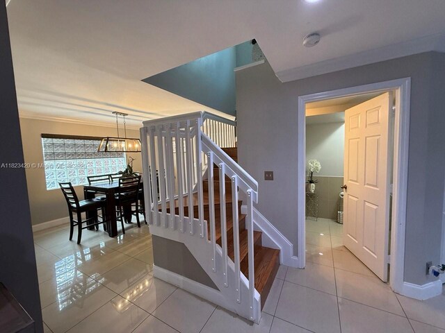 4280 NW 1st Pl, Deerfield Beach, FL 33442 - stairs with tile patterned floors, a chandelier, and crown molding