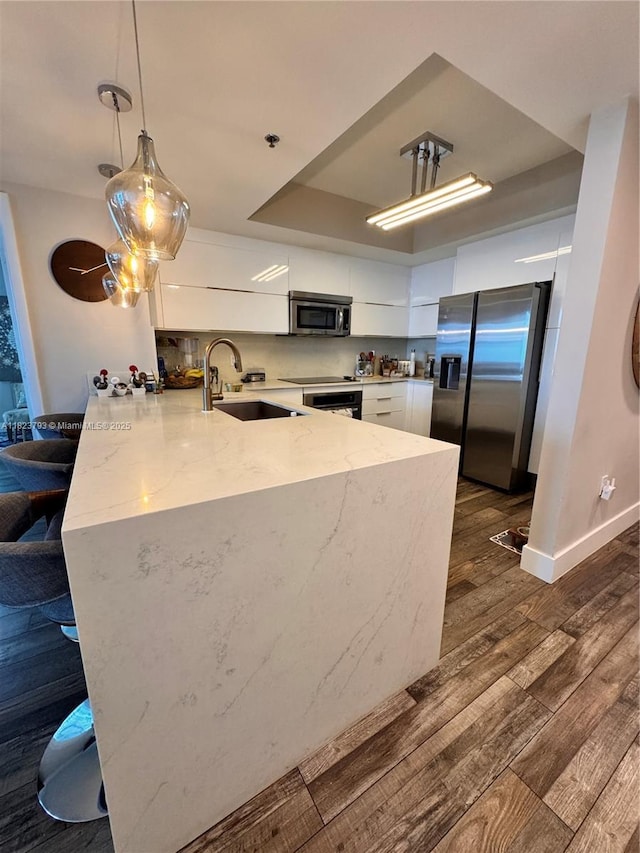 2681 N Flamingo Rd Unit 908S, Sunrise, FL 33323 - kitchen featuring appliances with stainless steel finishes, a peninsula, dark wood finished floors, white cabinetry, and light stone counters