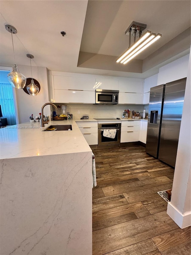 2681 N Flamingo Rd Unit 908S, Sunrise, FL 33323 - kitchen with appliances with stainless steel finishes, white cabinets, modern cabinets, dark wood-style floors, and hanging light fixtures