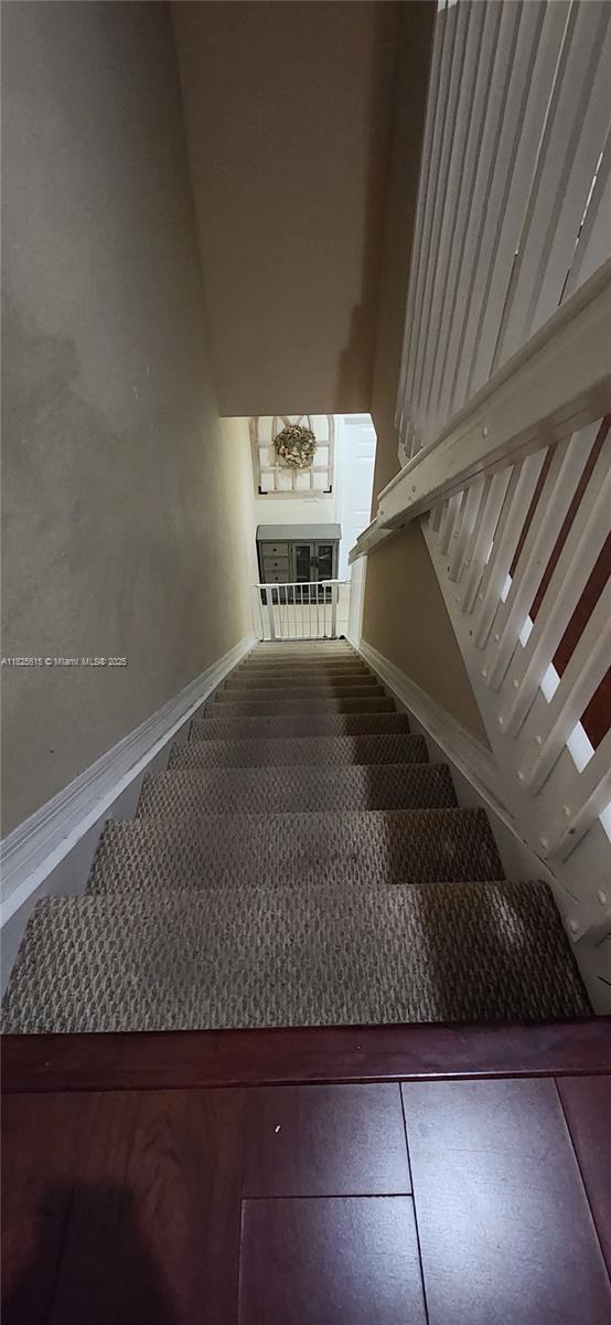14111 SW 49th St Unit 8, Miramar, FL 33027 - staircase featuring baseboards and a high ceiling