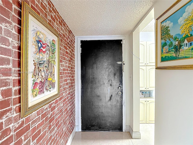 8635 NW 8th St Unit 103, Miami, FL 33126 - hallway featuring brick wall, a textured ceiling, and light tile patterned floors