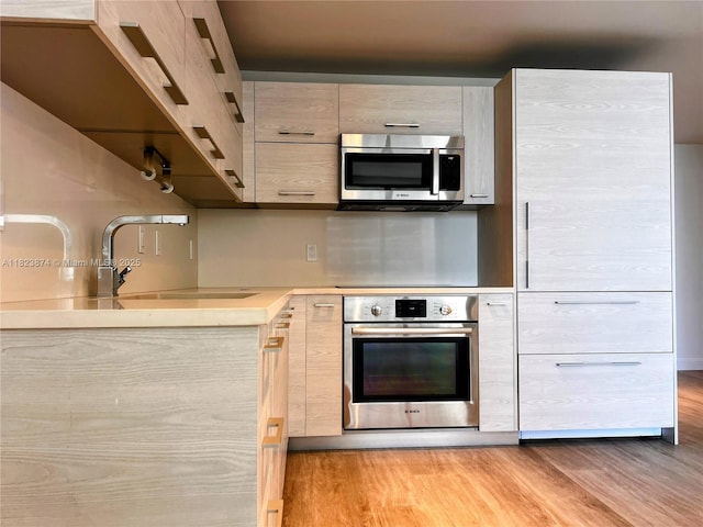 45 SW 9th St Unit 3602, Miami, FL 33130 - kitchen with appliances with stainless steel finishes, modern cabinets, light wood finished floors, and light countertops