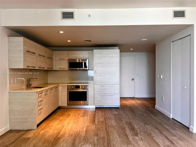 45 SW 9th St Unit 3602, Miami, FL 33130 - kitchen featuring stainless steel appliances, light brown cabinets, light countertops, light wood-type flooring, and recessed lighting
