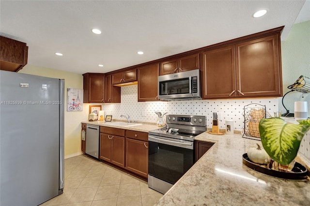 7100 NW 17th St Unit 402, Plantation, FL 33313 - kitchen featuring stainless steel appliances, tasteful backsplash, light tile patterned floors, light stone counters, and recessed lighting