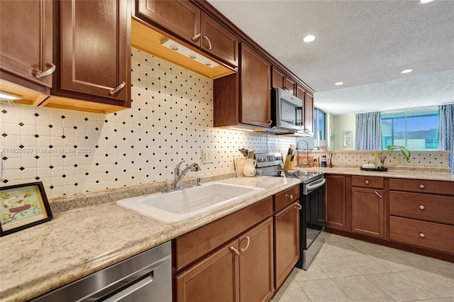7100 NW 17th St Unit 402, Plantation, FL 33313 - kitchen featuring stainless steel appliances, tasteful backsplash, light tile patterned floors, recessed lighting, and a peninsula