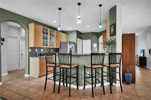 12779 SW 27th St, Miramar, FL 33027 - kitchen featuring stainless steel fridge, arched walkways, light tile patterned flooring, light brown cabinetry, and recessed lighting