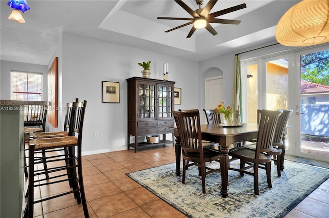 12779 SW 27th St, Miramar, FL 33027 - dining space with a tray ceiling, ceiling fan, light tile patterned floors, and arched walkways