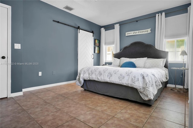 12779 SW 27th St, Miramar, FL 33027 - tiled bedroom featuring a barn door and baseboards