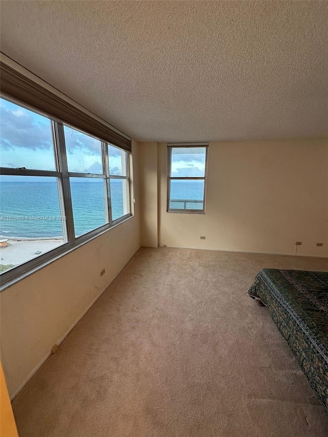 6039 Collins Ave Unit 1625, Miami Beach, FL 33140 - carpeted empty room with a textured ceiling and a water view