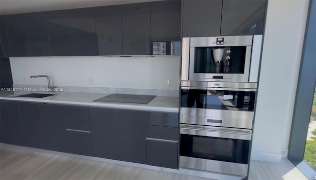 1451 Brickell Ave Unit 2306, Miami, FL 33131 - kitchen featuring black electric cooktop, modern cabinets, double oven, and light countertops