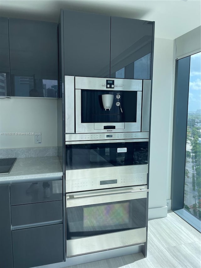 1451 Brickell Ave Unit 2306, Miami, FL 33131 - kitchen view of modern cabinets, gray cabinets, light countertops, and double oven