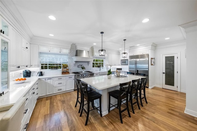 441 Grand Concourse, Miami Shores, FL 33138 - kitchen with built in appliances, a kitchen bar, backsplash, white cabinetry, and crown molding