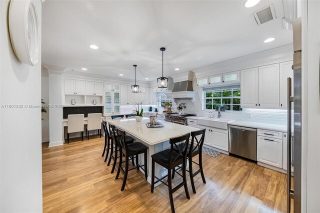 441 Grand Concourse, Miami Shores, FL 33138 - kitchen with appliances with stainless steel finishes, white cabinetry, a kitchen breakfast bar, light wood-type flooring, and recessed lighting