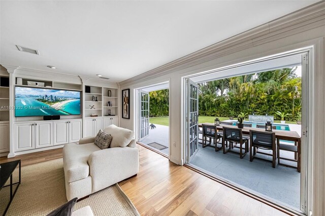 441 Grand Concourse, Miami Shores, FL 33138 - living room featuring light wood-style floors, plenty of natural light, ornamental molding, and built in shelves