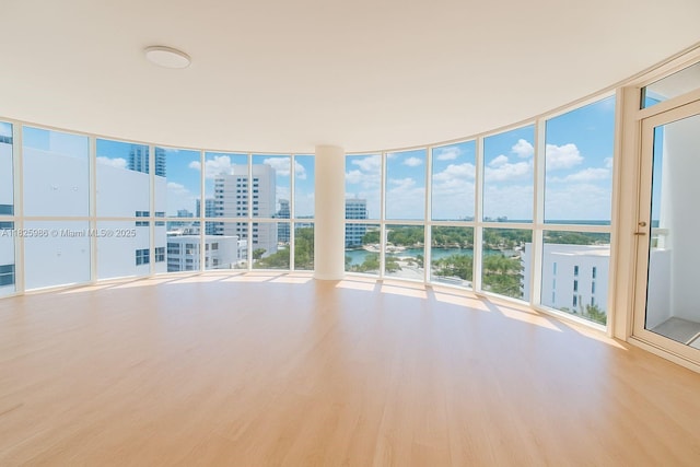 6301 Collins Ave Unit 1005, Miami Beach, FL 33141 - spare room featuring a water view, wood finished floors, expansive windows, and a city view