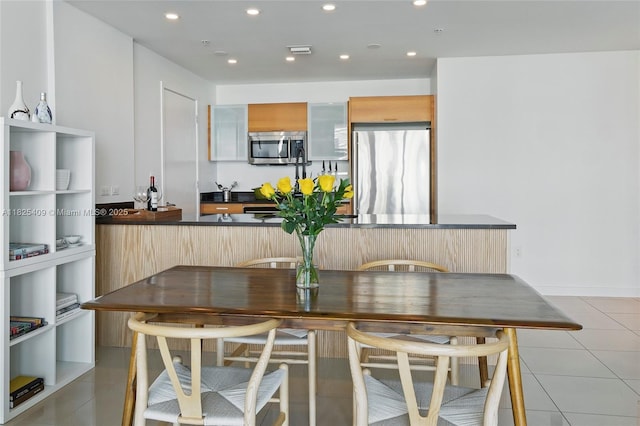 3301 NE 1st Ave Unit H2104, Miami, FL 33137 - kitchen with stainless steel appliances, dark countertops, light tile patterned floors, recessed lighting, and modern cabinets