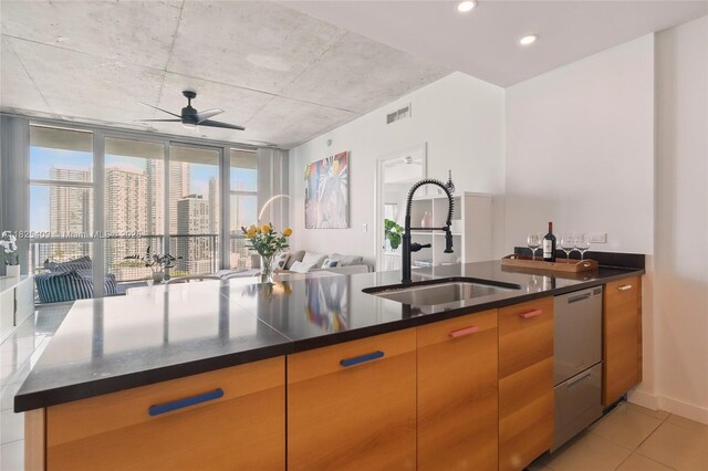 3301 NE 1st Ave Unit H2104, Miami, FL 33137 - kitchen with stainless steel dishwasher, ceiling fan, light tile patterned flooring, dark stone countertops, and open floor plan