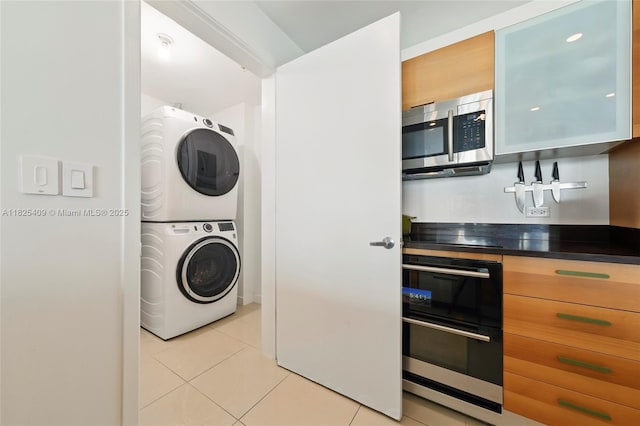 3301 NE 1st Ave Unit H2104, Miami, FL 33137 - kitchen with stainless steel microwave, stacked washer and clothes dryer, light tile patterned floors, dark countertops, and black stovetop
