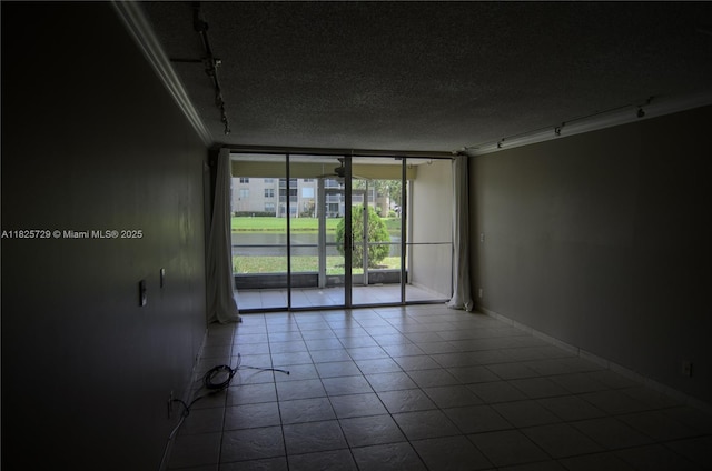 9420 Poinciana Pl Unit 115, Davie, FL 33324 - spare room featuring rail lighting, floor to ceiling windows, a textured ceiling, tile patterned flooring, and ornamental molding